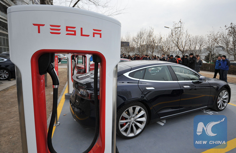 Owners have their Tesla electric cars recharged at a Supercharger station in north China's Tianjin, Jan. 24, 2015. [Photo/Xinhua]