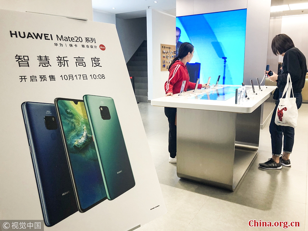 Customers look at display models of the Huawei Mate 20 smartphone series at a Huawei flagship store in Shanghai, October 17, 2018. [Photo/China.org.cn]