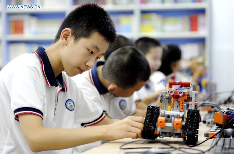 Pupils learn robot programming in Yi'an District of Tongling, east China's Anhui Province, July 19, 2018. [Photo/Xinhua]