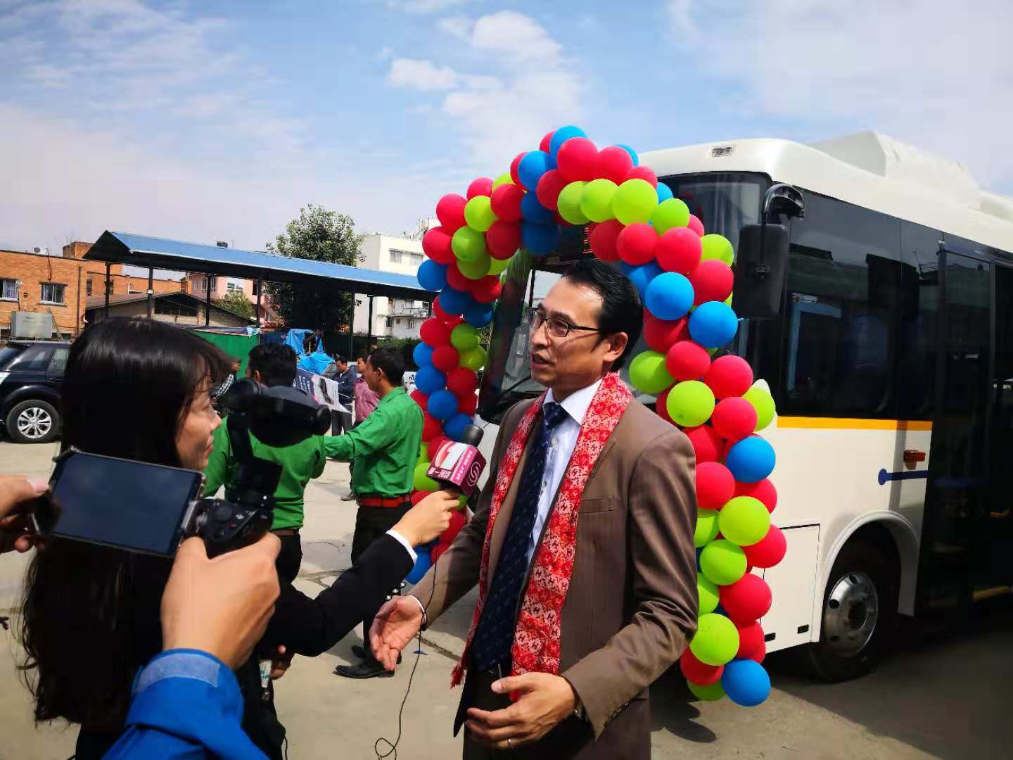Liu Xueliang (right 1), general manager of BYD Asia-Pacific Auto Sale Division, interviewed in front of a C6 bus in Kathmandu on Oct. 23, 2018. [Photo courtesy of BYD]