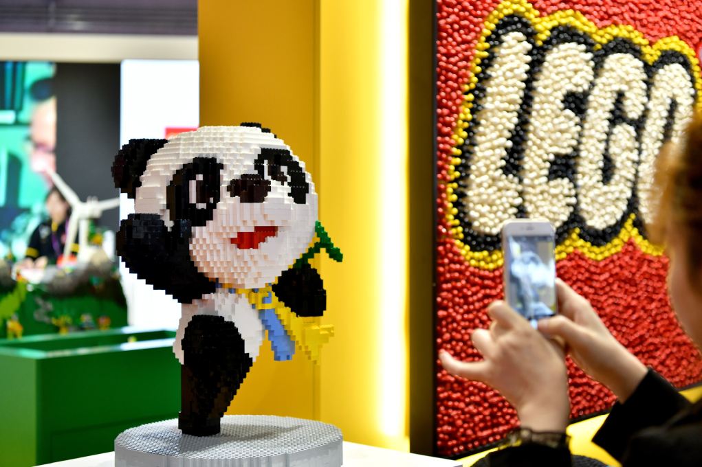 A visitor to the China International Import Expo takes a snapshot of Jinbao (the expo's mascot), which is built of Lego bricks. [Photo/Xinhua]