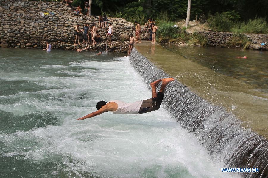 Kashmiri people bathe in stream to beat heat- China.org.cn